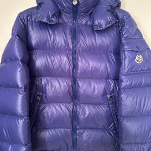 Moncler  - Moncler maya. Storlek 4. Skick 8/10 nån liten vatten fläck. Pris 7690kr kommer med dustbag. 