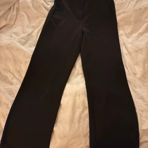 Svarta byxor från Vero Moda - Snygga svarta byxor från Vero Moda med en elegant och stilren design. Byxorna har en hög midja och en rak passform som ger en klassisk look. Byxorna är lite noppriga. Storlekslappen är bortklipp men demr storlek xs. 