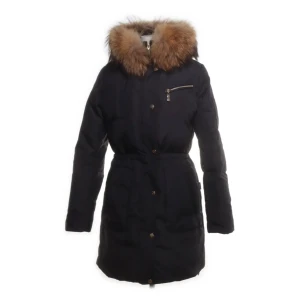 Svart dunjacka från Hollies - Snygg svart dunjacka från Hollies med en lyxig pälsdetalj på huvan. Jackan har en dragkedja och knappar framtill samt en praktisk bröstficka med dragkedja. Perfekt för kalla vinterdagar.