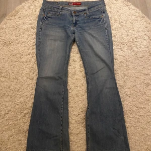 Lågmidjade bootcut jeans - Supa snygga blå lågmidjade jeans. Finns slitningar ner vid foten, så skriv gärna för fler bilder innan ni köper! Säljs pågrund av att dom är för korta!!❤️