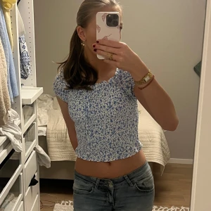 Blommig blå och vit topp från FB Sister - Söt blommig topp från FB Sister i blått och vitt. Toppen är croppad med korta och puffiga ärmar och har en snygg design som ger en fin passform. Perfekt för en somrig look! 🌸🥰💐👙💞
