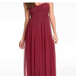 Vinröd axelbandslös långklänning - Superfin balklänning från Nelly! Endast använt en gång. Jag är 168 och den går ner till marken med matginal i klackar. Den har även gummi inuti så att den inte ramlar ner🫶