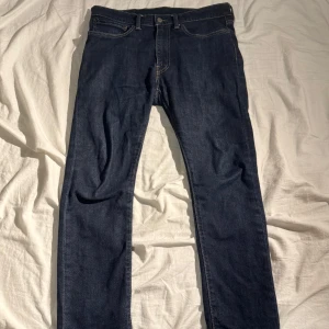 Mörkblå jeans från Levi's - Snygga mörkblå jeans från Levi's med klassisk femficksdesign och gul kontrastsöm. Perfekta för en stilren look. Märkesetikett på bakfickan.storleken är 34W 32L men jag håller absolut inte med. Jag skulle mer säga 30/31W 30L. Skick 8,5/10