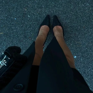 Svarta spetsiga pumps - Eleganta svarta pumps med spetsig tå och ett paljett-liknande mönster. Perfekta för en stilren look och enkla att matcha 