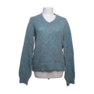 Blå stickad tröja från JDY - Mysig blå stickad tröja från JDY med v-ringning. Perfekt för kyliga dagar med sin långa ärmar och bekväma passform. Ett måste i garderoben för en stilren look.