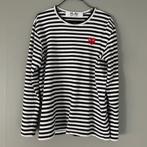 CDG PLAY långärmad tröja - Fin långärmad tröja från CDG PLAY. Inga fläckar eller så, bara ett litet hål bak vid nacken. Kommer ej till användning därav säljes. ⚠️ Var god följ budgivningens regler ⚠️