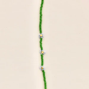 Armband - Ett hemmagjort blommigt armband med blå blommor. 