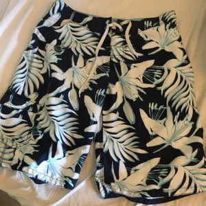 Badbyxor med ölöppnare. 32 - Knappt använda badbyxor med en ölöppnare som sitter fast i  höger byxficka. Resårgylf. 