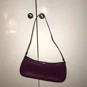 Plommonfärgad baugettebag - Såå fin plommonfärgad liten handväska i läderimmitation typ. Knappt använd så den är i bra skick med fräsch insida osv. Köpt på second hand men den är som ny!