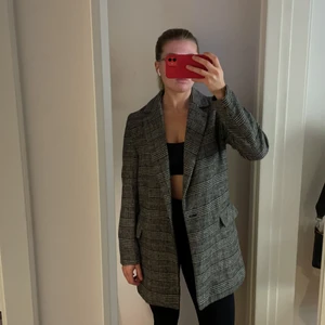 Grårutig kappa - En relativt tunn grårutig kappa från Zara i stl. XS