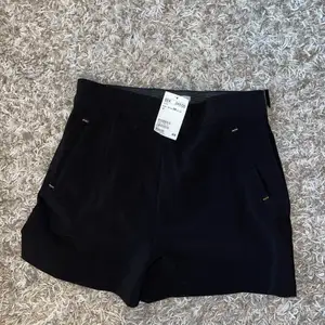 Oanvända svarta shorts med gulddetaljer från H&M, lappen kvar. 