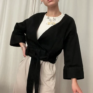 Croppad söt kimono-jacka i strl S! - Superfin croppas tunn jacka i kimono-stil från Light Before Dark. Gjord i tunnt men starkt bomullstyg. Är helt svart, var bara tvungen att höja ljusstyrkan på bilderna för att detaljerna skulle synas :) Passar alla från XS-L då den är luftig men man kan dra åt den i midjan. Även snygg öppen. Tycker att den lätt lyfter en vardagsoutfit från vanligt till genomtänkt. Enbart använd 2-3 gånger, hoppas den kan älskas lite mer av dig! 