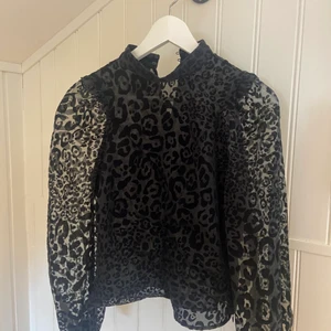 Partytopp i leopardmönster - Perfekt partytopp nu när det blir kallare. Armarna är genomskinliga. Svart leopardmönster i sammetsmaterial. Aldrig använd.