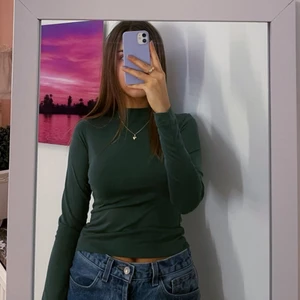 Mörkgrön topp - Mörkgrön långärmad topp med hög hals från monki!