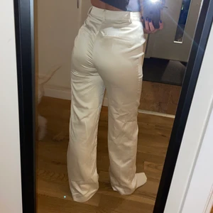 Kostymbyxor från NAKD - Snygga kostymbyxor i champangefärg. Riktigt bra passform. Använda 1 gång. Storlek 32 men passar absolut en som har 34.          Emma Ellingsen x NA-KD