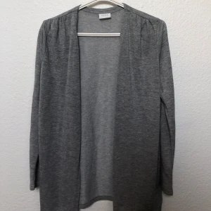 VILA grå kofta - Säljer ytterligare en kofta från Vila som inte heller kommer till använding! Koftan är i nyskick och är ocksp lätt och tunn😍 Väldigt fin grå färg dessutom!