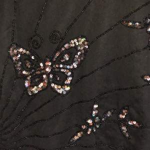 svart linne med glitterfjärilar!!! ett linne med typ ”meshlager” över med glittret på sig. köpt secondhand men i superbra skick! frakt +55kr
