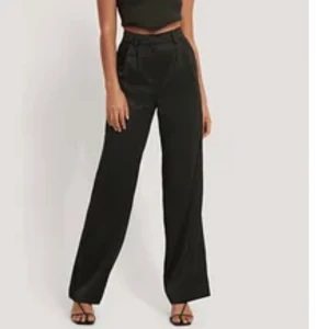 vida satinbyxor från NA-KD - oanvända satinbyxor, vida, svarta, från emma ellingsens kollektion med NA-KD