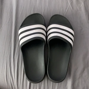 Tofflor från Adidas storlek 37/37,5  - Ett par skit snygga tofflor från adidas dom är i bra skick men lite smutsiga på undersidan då jag använt dom några gånger men inte mycket alls. Har tvättat bort det mesta men det är några fläckar kvar annars är dom i topp skick! Dom är jätte fina och verkligen jätte sköna. Frakt ingår. 