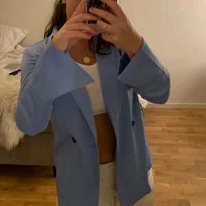 Blå mjuk kavaj - Skitsnygg blå kavaj i mjukt polyestertyg med svarta knappar och slit vid ärmarna. Helt oanvänd, prislapp och extraknappar finns kvar. Storlek XS men har en oversized fit så passar från XS-M. Frakt: 48kr🥰💙