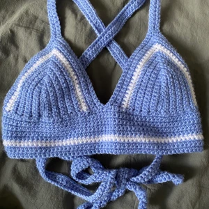Virkad topp blå - Egengjord virkad topp, blå med vita detaljer. Har extra långt band som kan knytas som man själv önskar (exempel på bilden). Kupa A/B, bandet är justerbart.💖 Kan göras i fler färger och storlekar 