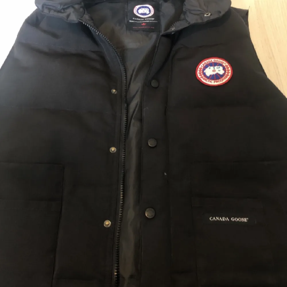 Canada Goose väst i storlek M. Bra kvalité men zippen e borta så man får använda knapparna istället. . Jackor.