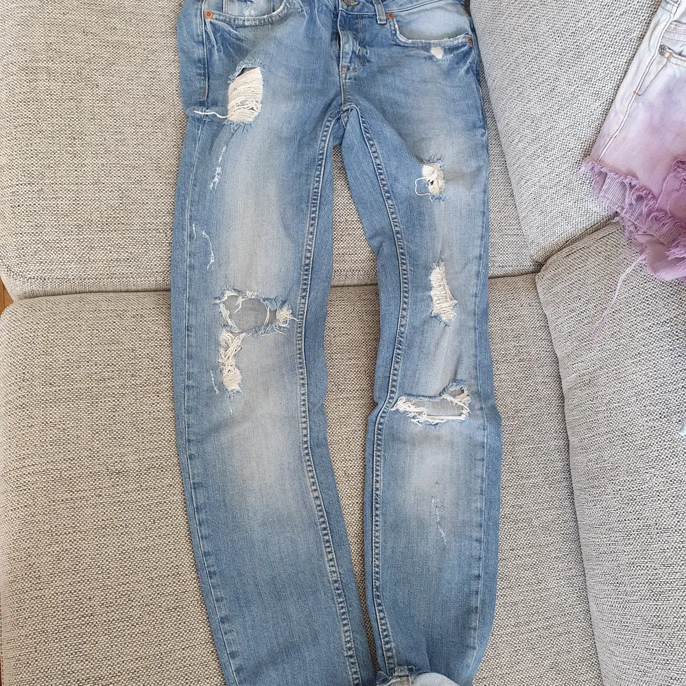 Snygga Ljusblåa jeans med sliten look på . Rak modell ner till ej stuprör.  Dom är I fint skick . Storlek 28. . Jeans & Byxor.
