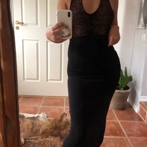 svart klänning med slits  - SKITsnygg klänning från tidigt 2000-tal som är halterneck + har slits. super med en oversize skinnjacka & hårklämma. Säljer pga aldrig använd! Sitter snävt ✨