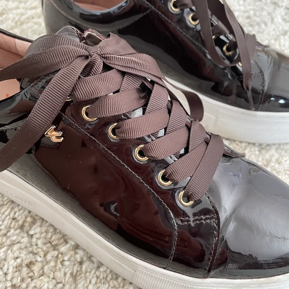 Säljer sneakers från K.COBLER. Dessa är mörkbruna lack med leopard detalj vid hälen. Säljer då de inte kommit till användning. Endast använda 1 gång, som nya därav priset. Nypris : 1000kr. Skor.