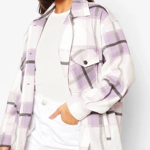 Helt ny! lila mönstrad skjortjacka  - En helt ny oversized skjortjacka med lapp kvar som endast är testad. Säljer pågrund av att den tyvärr var förstor. Köpt på boohoo i storlek M med fickor och super mysigt vitt tyg inuti. När jag fick hem jackan så märkte jag att det var små felsydda svarta märken på det ljusa tyget, vid den ena axeln. Det syns inte lika väl när man har jackan på sig. Felet syns på de två sista bilderna. Annars är skjortjackan super fin! Den passar perfekt att använda nu en lite kallare vårdag eller med en tunnare topp/tröja på sommaren!💜                   Frakt tillkommer 
