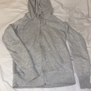 Grå basic zip-hoodie - Super mysig zip-hoodie, fin grå färg, lite högre i kragen, använd men fortfarande i bra skick! Från Cubus! Säljer för att jag har andra, jag använder mer! 