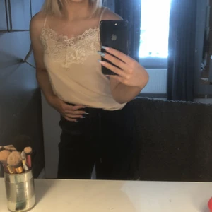 Linne  - Ett ljus rosa/ beige linne med spett upptill 