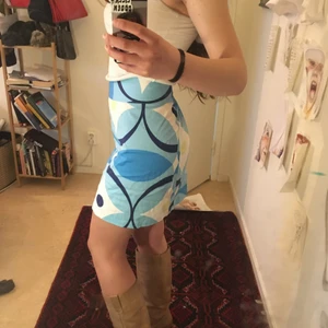 Kjol i 60-talsstil  - Jättesöt ljusblå kjol i lite marimekkoliknande mönster. Bra skick. Strl m, lite för stor på mig som har strl S så jag har använt säkerhetsnål på bilderna:))