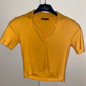 Tajt top med krage - Söt top från Zara med krage. Gul-orange med v ringning. Tajt men passar storleken. Croppad. Använt Max 1 gång (knappt). 