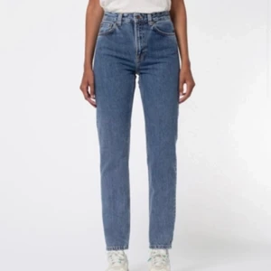Jeans från nudie jeans - Byxorna är från märket nudie jeans. Det är storleken W28 L32. Det är en ljusare blå färg med orange detaljer och knapparna är en fin bronsig färg.