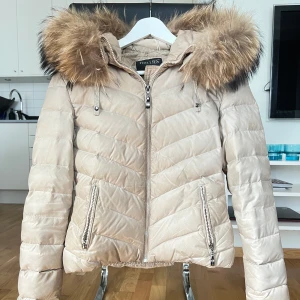 Hollies jacka - Hollies jacka i storlek 34, köpte för några vintrar sedan men hängt i garderoben större del av tiden. Använt skick då pälsen som sitter fast med resårband har töjts ut (inget som syns när man har på sig jackan) samt att den är lite smutsig (går att få bort på kemtvätt). 