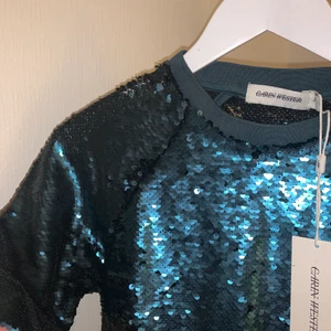 Glittrig topp  - En grön glittertopp från Carin Wester 💚✨ Aldrig använd, lappen hänger kvar. Storlek 34, men jag som vanligtvis har 36 kan ha den✨ så den är lite stor i storleken! 