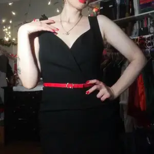 Svart deadstock klänning i 80-tals stil med knappdetaljer på sidan och slits samt smickrande halsringning