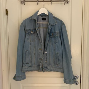 Jeansjacka - Jeansjacka från Nelly i storlek 36 i ljus tvätt. Modellen har slitningar/hål vid armbågarna. 