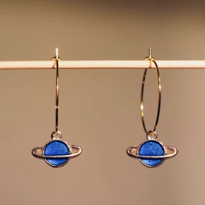Örhängen Blå planeter - Handgjorda, nickelfria örhängen 🌙 Finns i flera färger och former! Ringen är 25mm i diameter, och hänget varierar i storlek från 10mm och uppåt. 🪐 Köp 1 par för 40kr, 2 par för 70kr, 3 par för 100kr! Du får också med en fin liten presentpåse. Frakt på 13kr tillkommer 💫