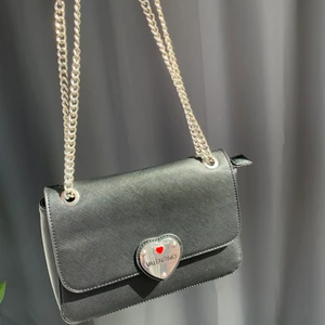 Valentino by Mario väska - Valentino by Mario väska. Inköpt på Zalando för ca. 600kr. Användes sparsamt och i väldigt fint skick! Finns några mindre repor på metallhjärtat men inget man lägger märke till vid första anblick.  Väskan går att ha både som handväska och axelremsväska tack vare de justerbara kedjorna. Dustbag finns.