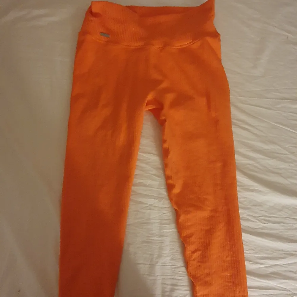 Det är ett par tränings tights från aimn, dom är i storlek M. Dom ser orangefärgade ut men dom är mer åt det coralfärgade hållet, dom är helt oanvända och dom är i ankel längd alltså inte full längd som men dom är inte korta men inte en fullängd. jag är 172cm och det är ungefär 15 cm kvar till min ankel när jag har på mig dom.. Jeans & Byxor.