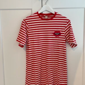 T-shirtklänning - Säljer denna rödrandiga t-shirtklänning med coolt tryck från H&M. Den är använd ett fåtal ggr och är i fint skick. Priset är exklusive frakt☺️