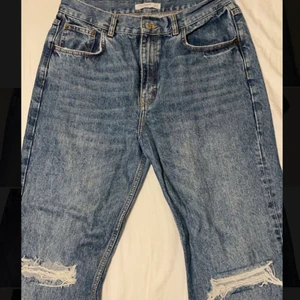 Bootcut jeans med hål vid knäna - Säljer dessa jätte coola bootcut jeans med slits ned till och hål vid knäna. De har tyvärr lite slitningar nedtill vid benen men annars är de i jättefint skick😊 (ville få med så mycket av byxan på första bilden därför den kan se konstig ut)💕