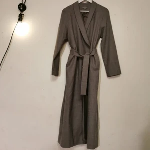COS kappa  - Gråmelerad vårkappa från COS i ull Storlek 36 Fodrad Med skärp Innerficka 2 dolda fickor på sidan Sprund mitt bak