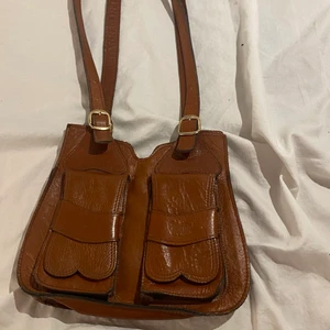 Skinn väska  - Det är äkta skinn den är i extremt bra Skick för att vara så gammal  , har fått den av min mormor och hon köpte den när hon va yngre så hon kommer inte ihåg ny pris 