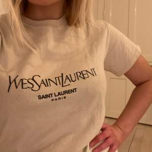 T-shirt med Yves Saint Laurent signatur logga, men ej äkta därav priset. Annars superfin i normal passform stl S
