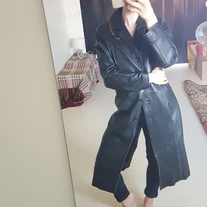 Lång svart rock i äkta skinn - En snygg lång rock/kappa i äkta skinn av märket B-Young, med knappar framtill och en innerficka. Frakt tillkommer: 99kr spårbart.