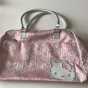 Rosa Hello Kitty väska. Väskan är från typ 2000-talet, den är använd men i väldigt bra skick. Det finns ett innerfack och ett fack på framsidan med deagkedja. Den är cirka 40x30 cm. Köparen står för frakten🌸