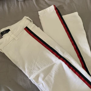 Byxa - Fina vita byxor med en röd och svart slits. Knappt använda då det inte är min stil men väldigt mjuk och skön kvalite. Storlek 36 köpta på bershka. Man får stå för frakten själv.